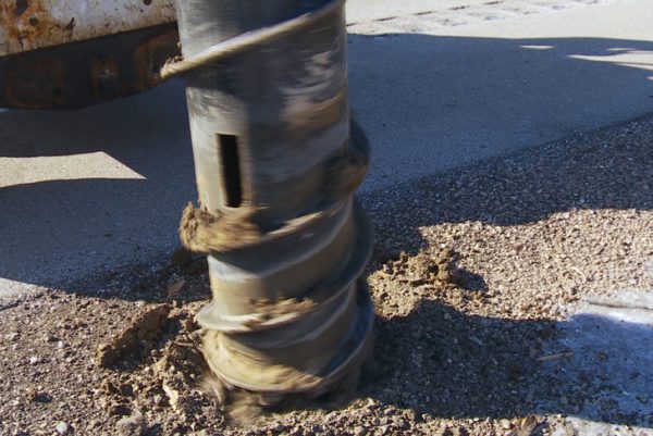 post removal in frozen ground drilling with hydraulic attachment for a skid steer