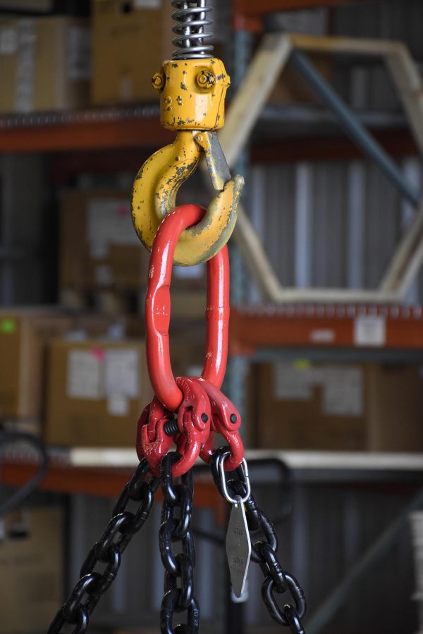 close up of magnet suspended by hook and chains